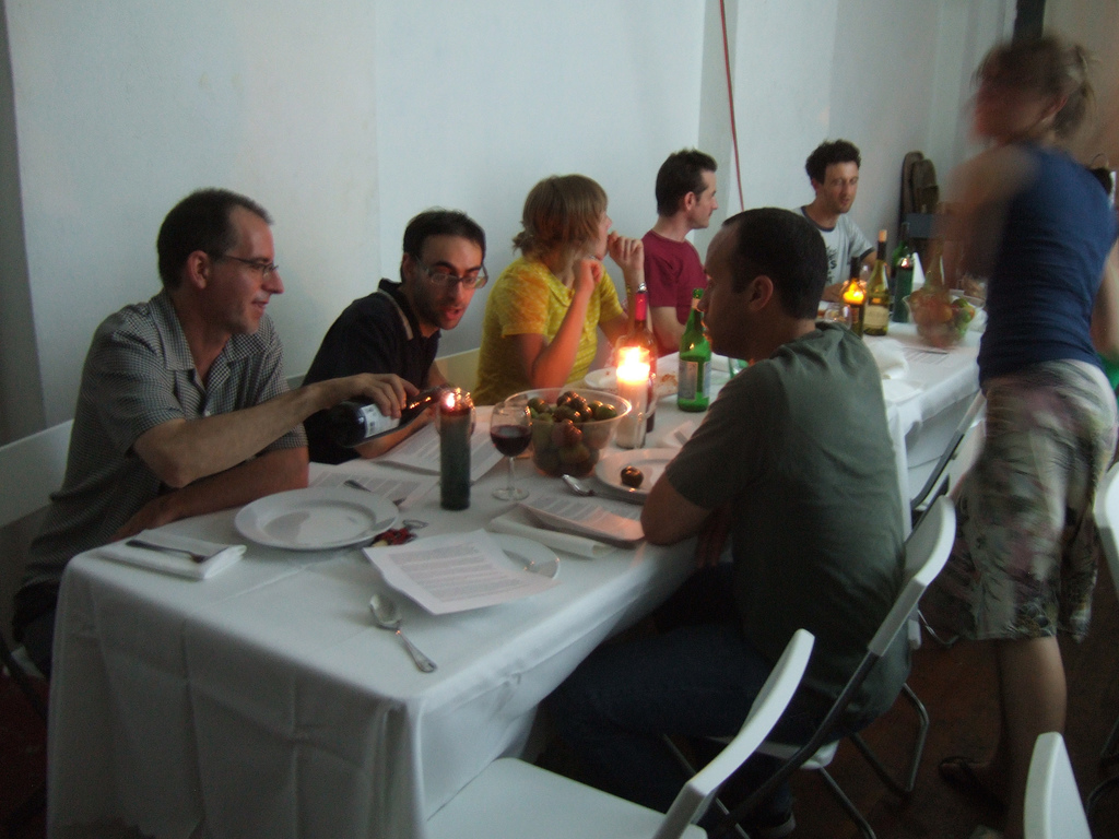 Photograph of guests at the gallery event, eating pasta sauce made from the tomatoes used in the installation.